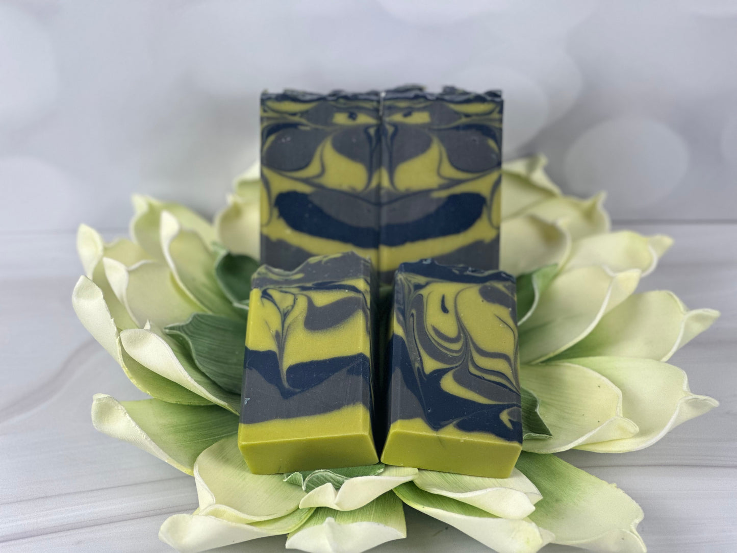 Gray blue green soap sitting on top of a flower