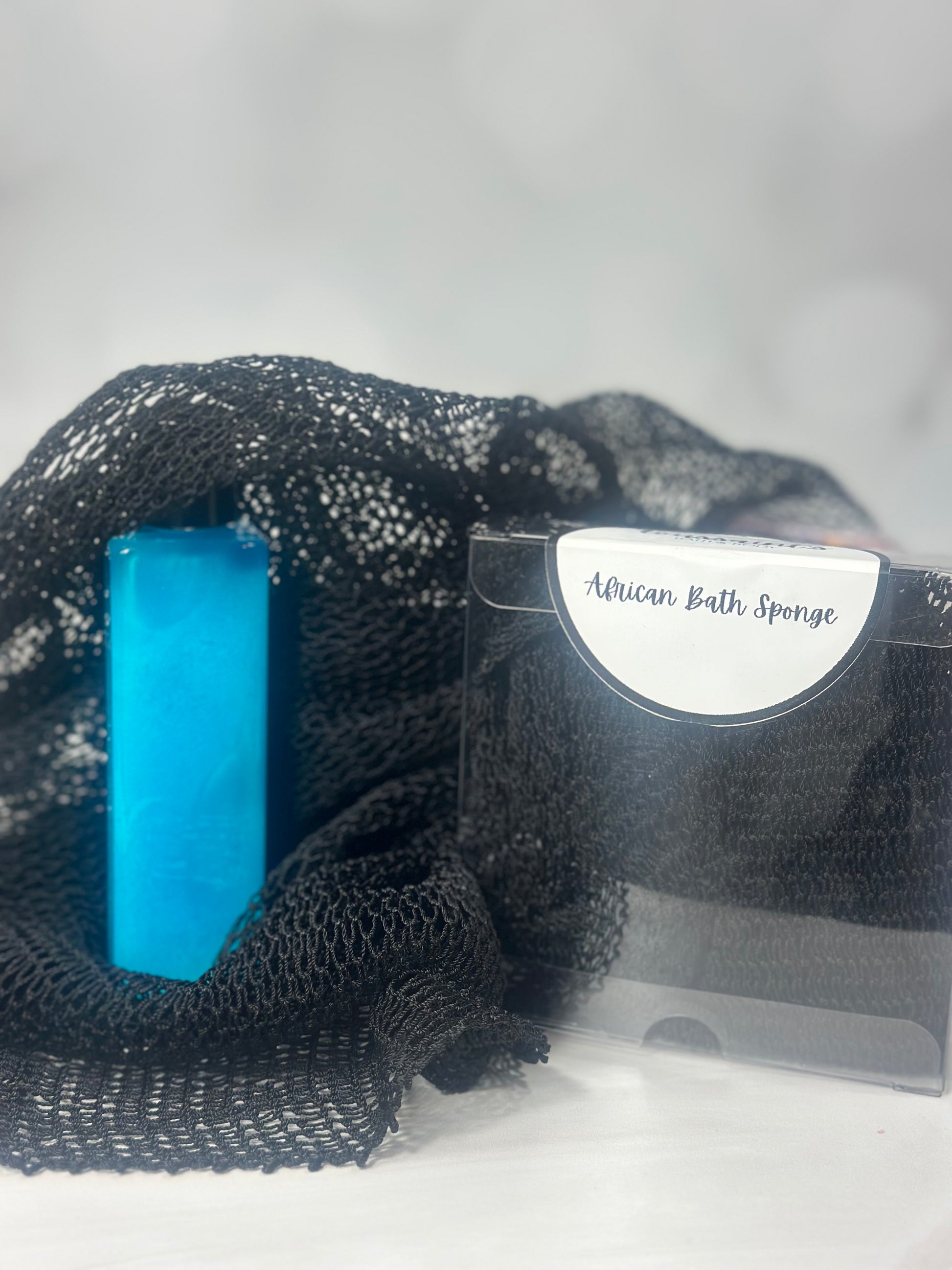 Black net sponge for use with soap or body wash. Displayed with an aqua colored bottle of body wash